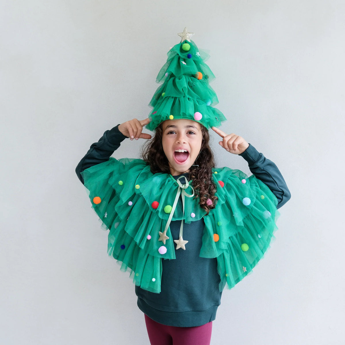 Girl wearing the Mimi & Lulu Christmas tree hat and cape