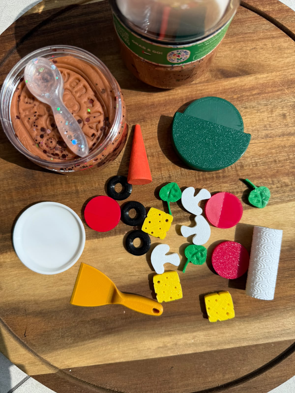 Contents of the Pizza playdough jar laid out on a wooden board