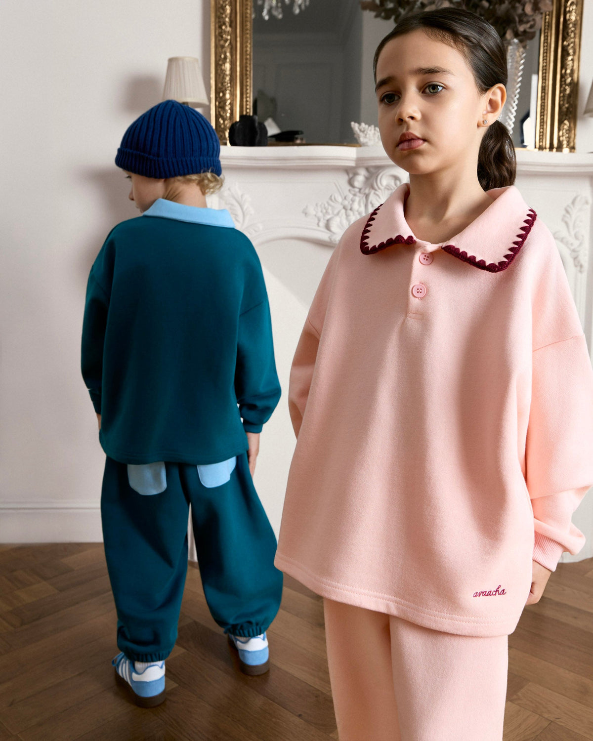Girl in the Avaacha Mimi Tracksuit next to a boy in the teal Leo Tracksuit