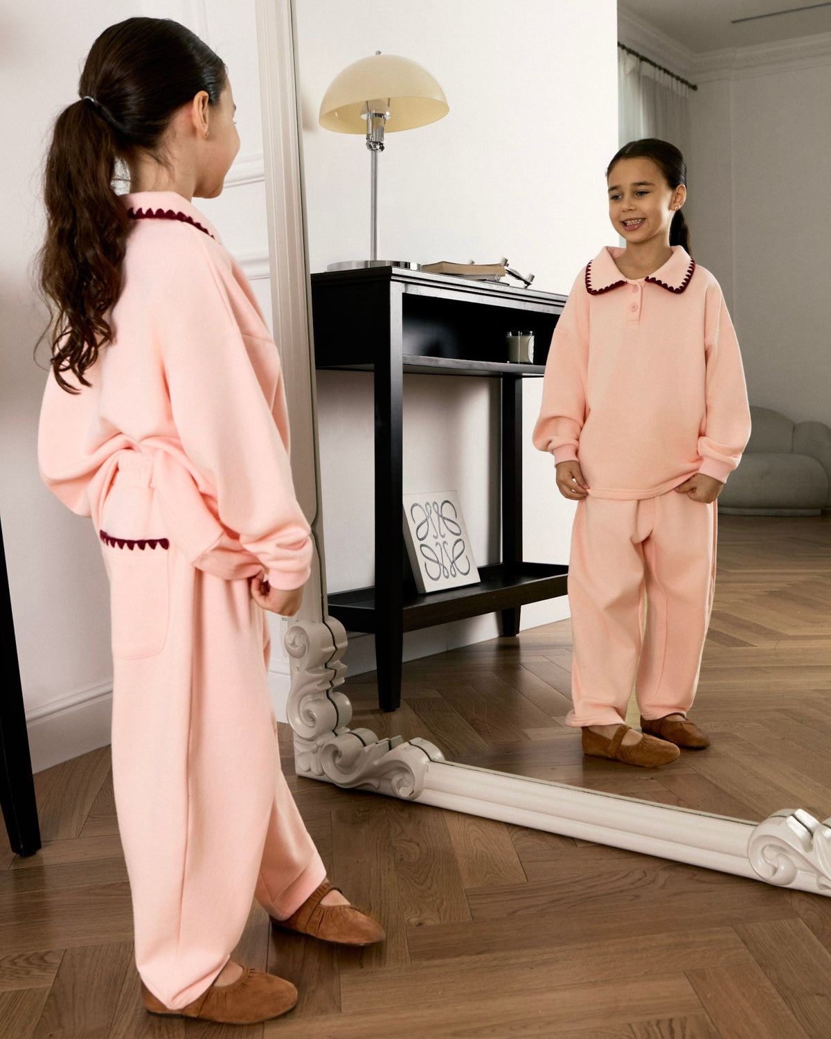 Girl in the pink Avaacha Mimi Tracksuit looking in a mirror