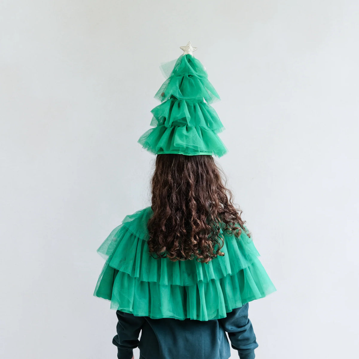 Child wearing the Mimi & Lulu Christmas tree cape and hat, back view