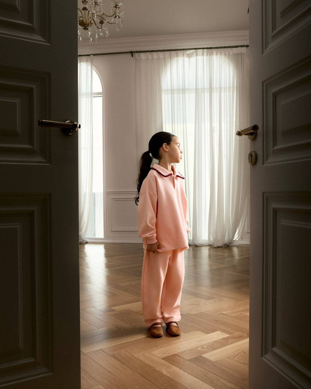 Girl wearing the Avaacha Mimi Tracksuit in Bubblegum at home