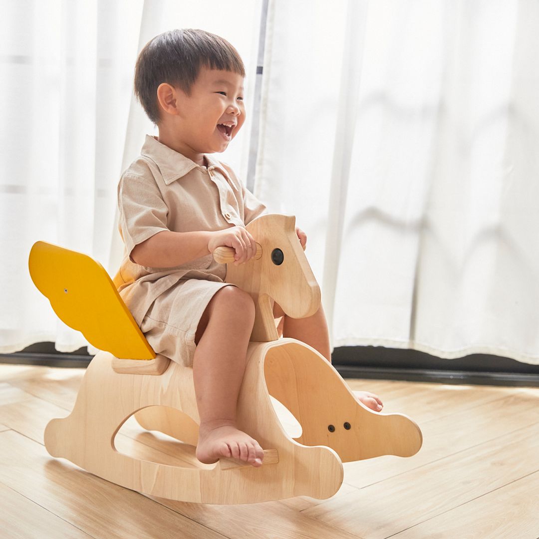 Little boy rocking on the PlanToys Rocking Pegasus