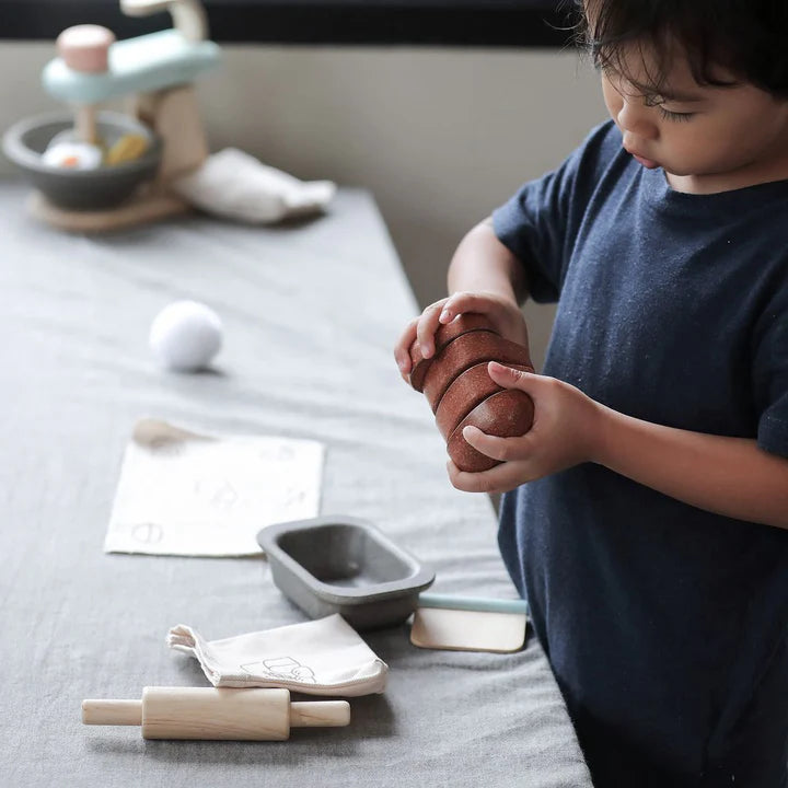 Child playing with the PlanToys bread loaf set at a table