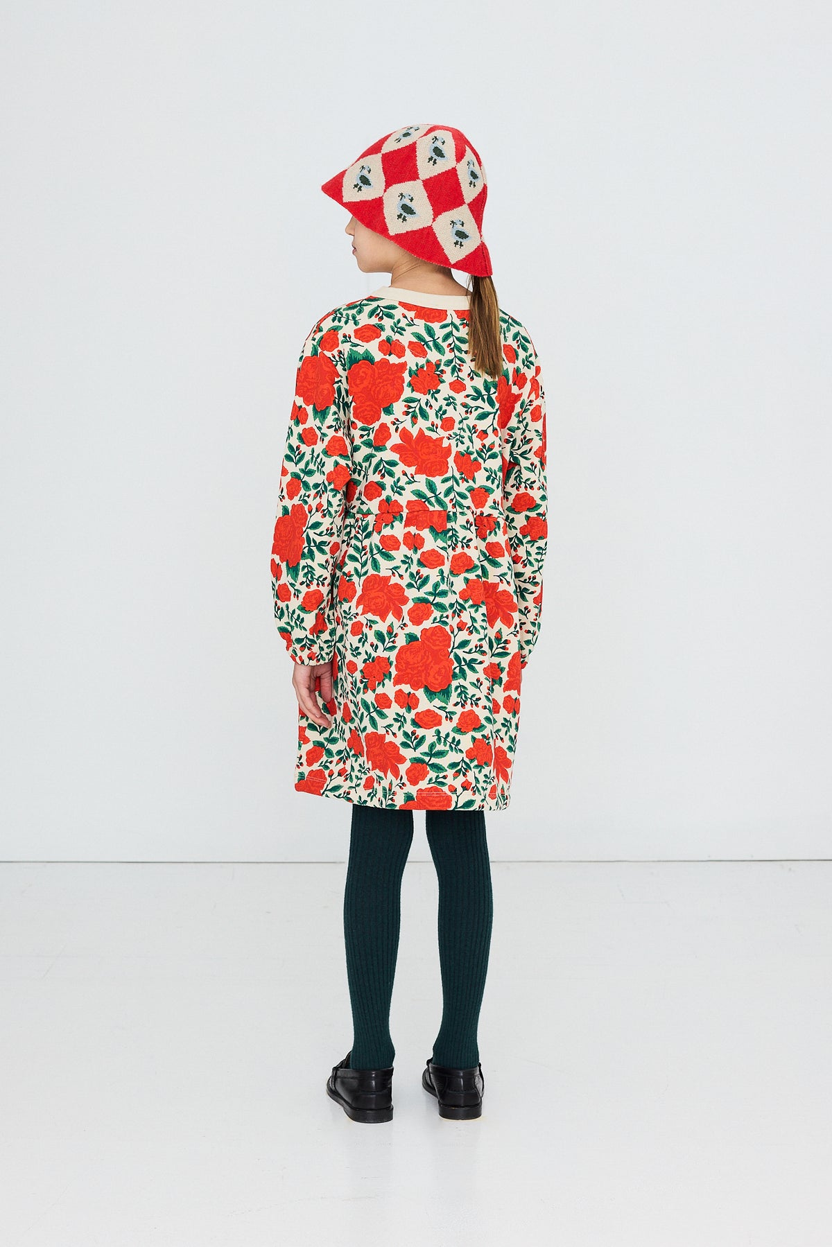 Back view of a child in the Tinycottons Roses dress and hat