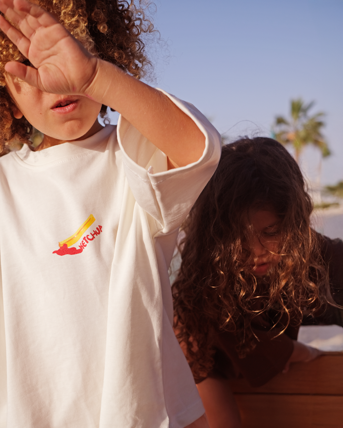 Child wearing the oversized white Oupah Ketchup Tee