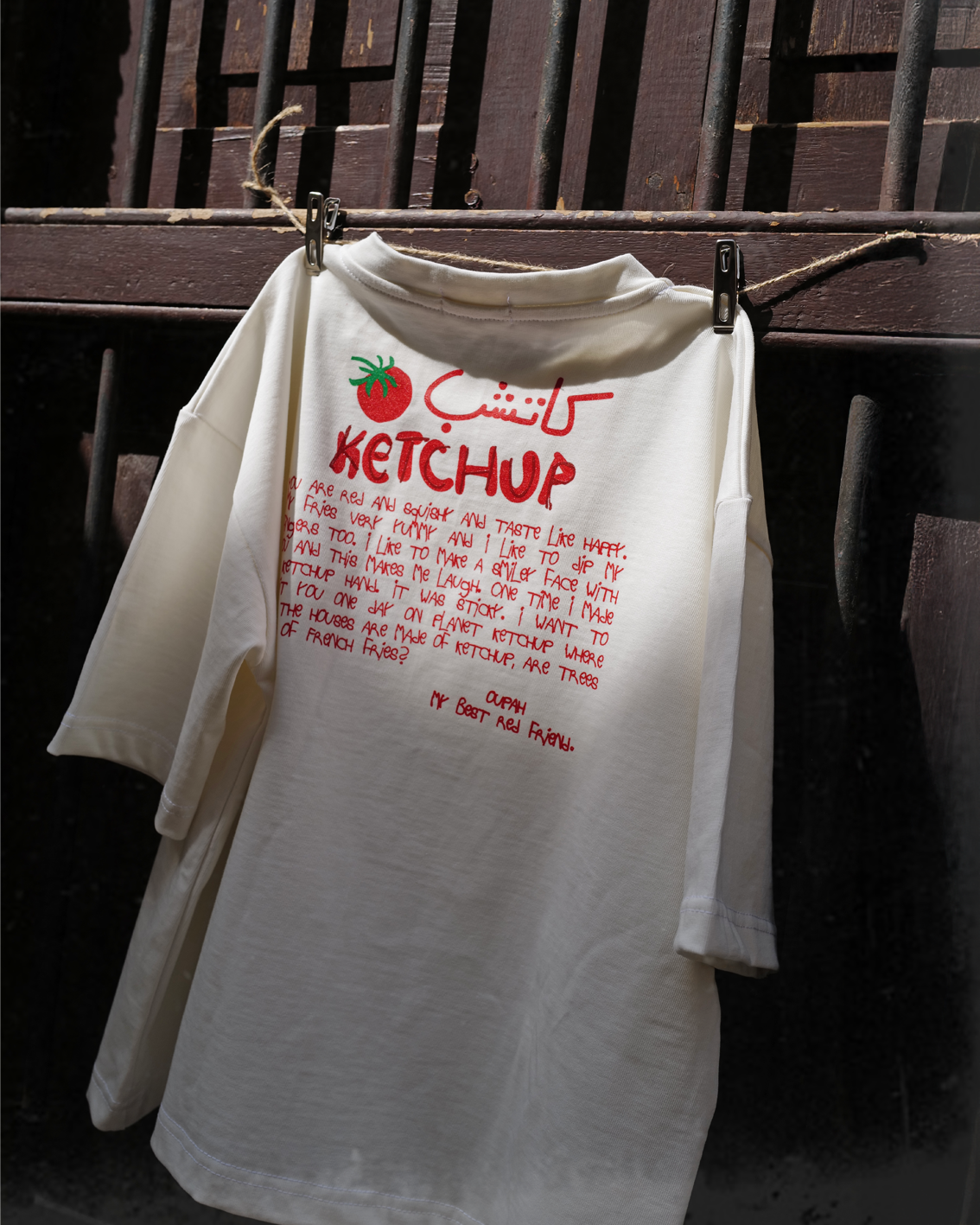 Oupah Ketchup Tee hanging, showing the red back print